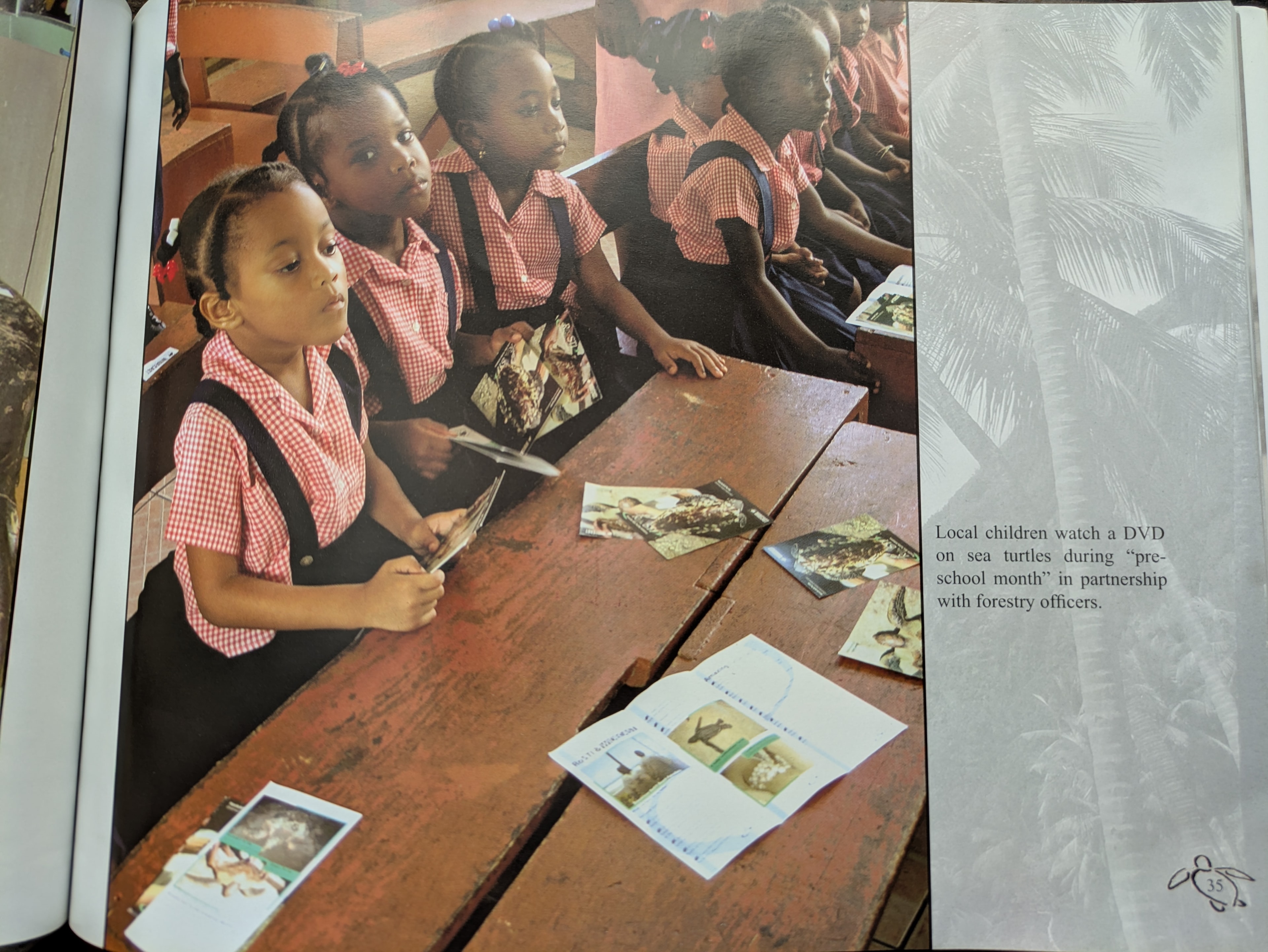 Local children watch a DVD on sea turtles during pre-school month in partnership with forestry officers, La Plaine, Dominica